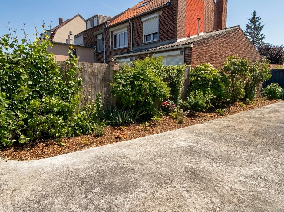 Jardin résidentiel avec clôture moderne en panneaux composite gris anthracite et poteaux métalliques noirs