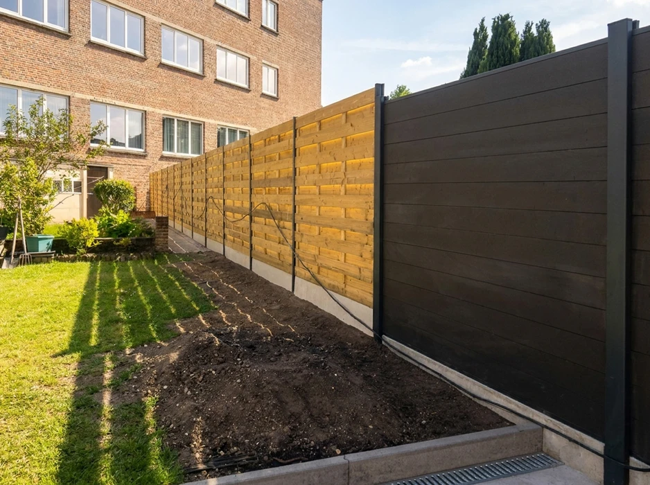 Jardin résidentiel avec clôture moderne en panneaux composite gris anthracite et poteaux métalliques noirs