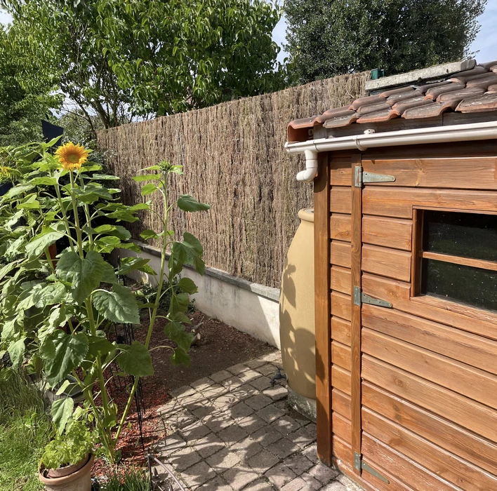 Jardin résidentiel avec clôture moderne en panneaux composite gris anthracite et poteaux métalliques noirs