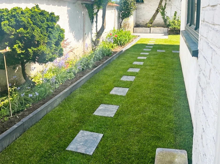 Clôture métallique résidentielle installée le long d'un trottoir pavé